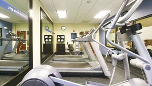 A gym with treadmills, elliptical machines, and dumbbells. - Hampton Inn North Brunswick / New Brunswick (North Brunswick)