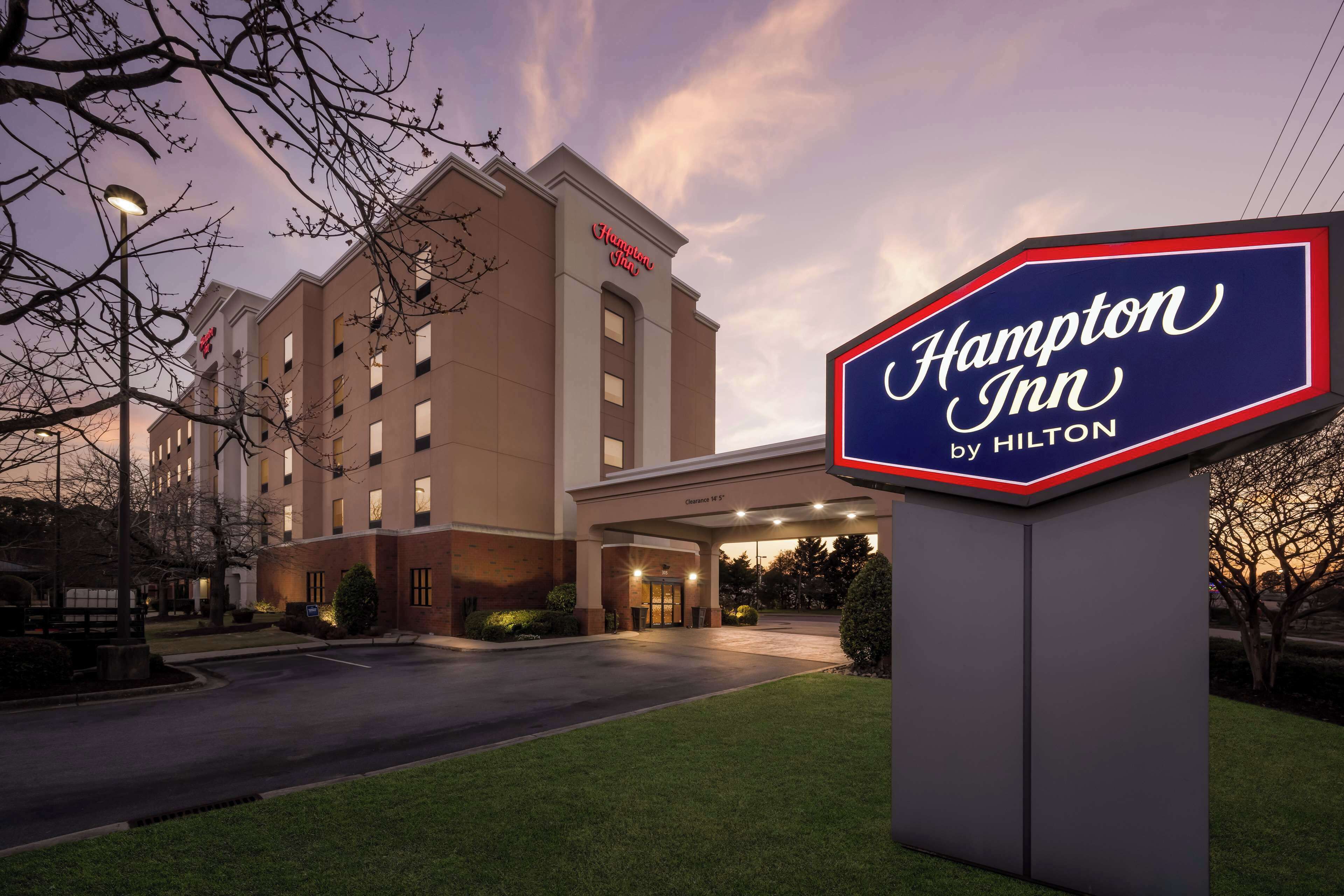 Ett Hampton Inn-hotell som tillhör Hilton-kedjan, med en väl upplyst entré och fri sikt över byggnadens fasad.