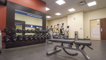 A gym with weightlifting equipment and cardio machines.
