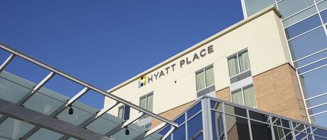 Un bâtiment moderne avec une façade en verre et l’inscription « HYATT PLACE » sur le côté.