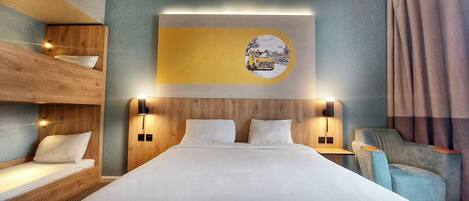 A hotel room with a wooden bunk bed, a large bed with white linens, a wall-mounted artwork, and a seating area with a chair.