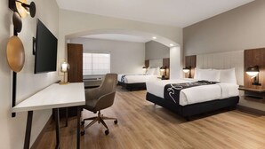 A hotel room with a desk, two beds, a TV, and a large window. - La Quinta Inn & Suites by Wyndham Port Arthur (Port Arthur)
