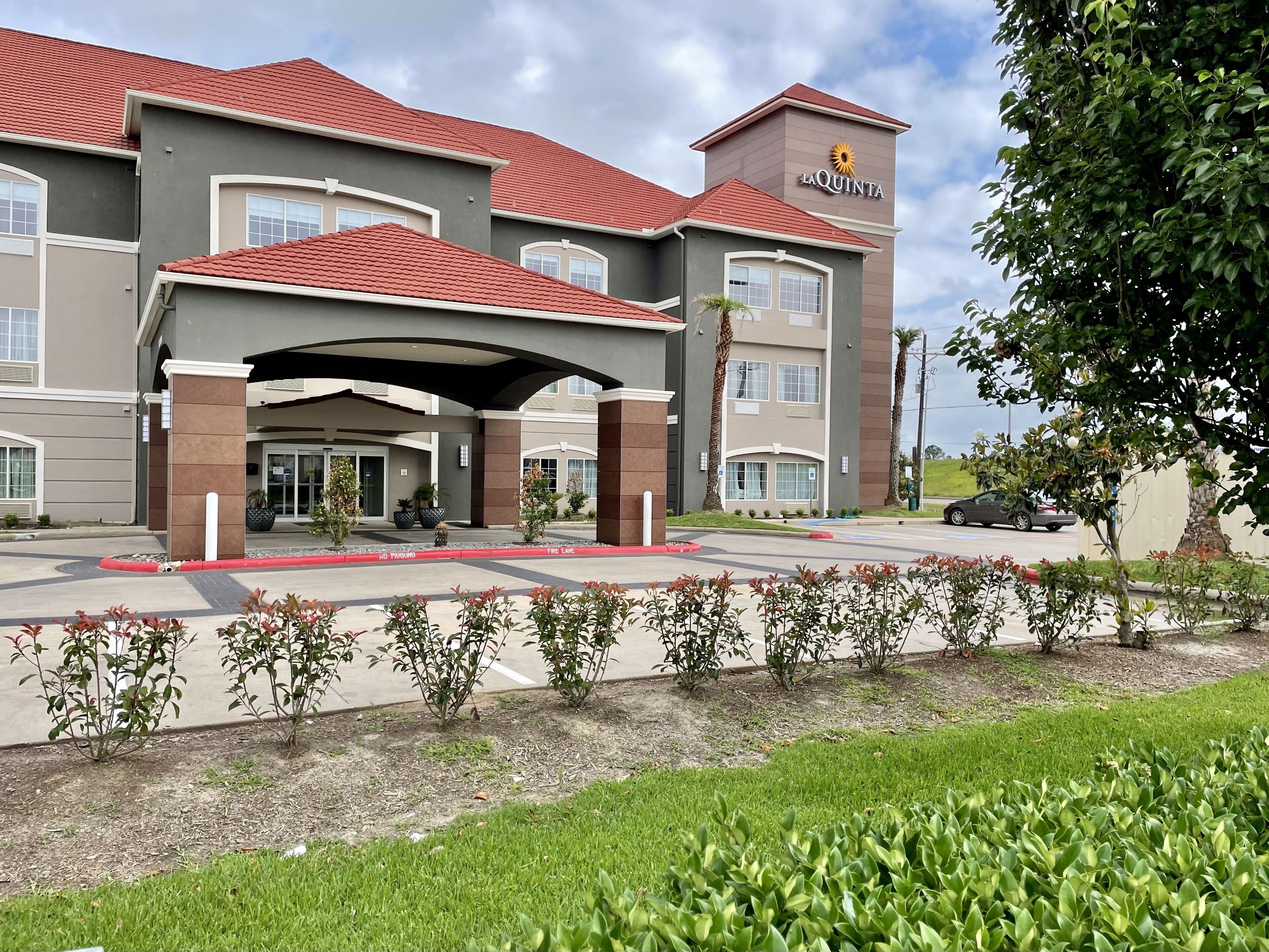 Un hotel con entrada cubierta, varias ventanas y un letrero que dice "La Quinta".