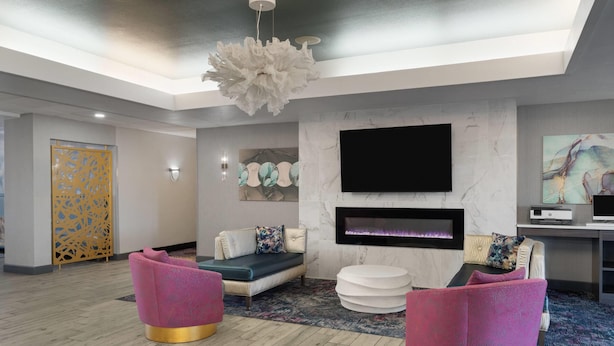 A modern living room with a fireplace, a flat-screen TV, and comfortable seating. - La Quinta Inn & Suites by Wyndham Tucumcari (Tucumcari)