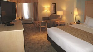 A hotel room with a bed, a desk, a television, a chair, and two lamps. - La Quinta Inn & Suites by Wyndham Tucumcari (Tucumcari)