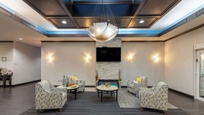 A spacious lobby with a modern chandelier, seating area, and a stone fireplace. - La Quinta Inn & Suites by Wyndham Mt. Pleasant (Mount Pleasant)