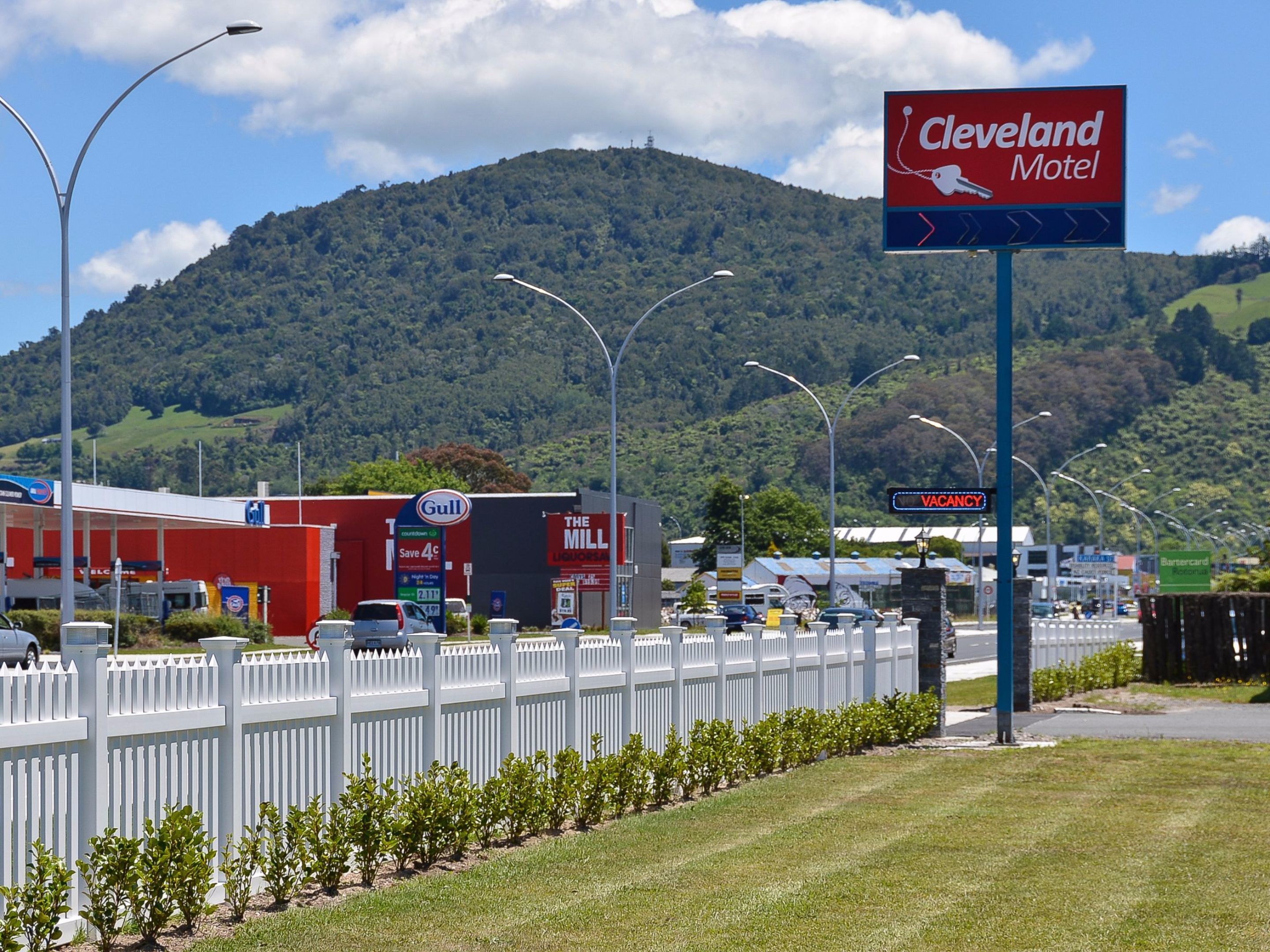 A motel sign with a mountain in the background.