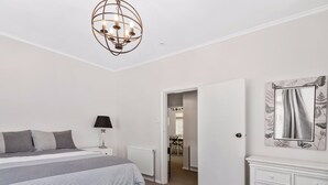 A bedroom with a bed, bedside table, lamp, and a dresser. - ASURE Cleveland Rotorua (Rotorua)