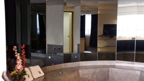 Un bany modern amb una banyera gran, un mirall i un lavabo.