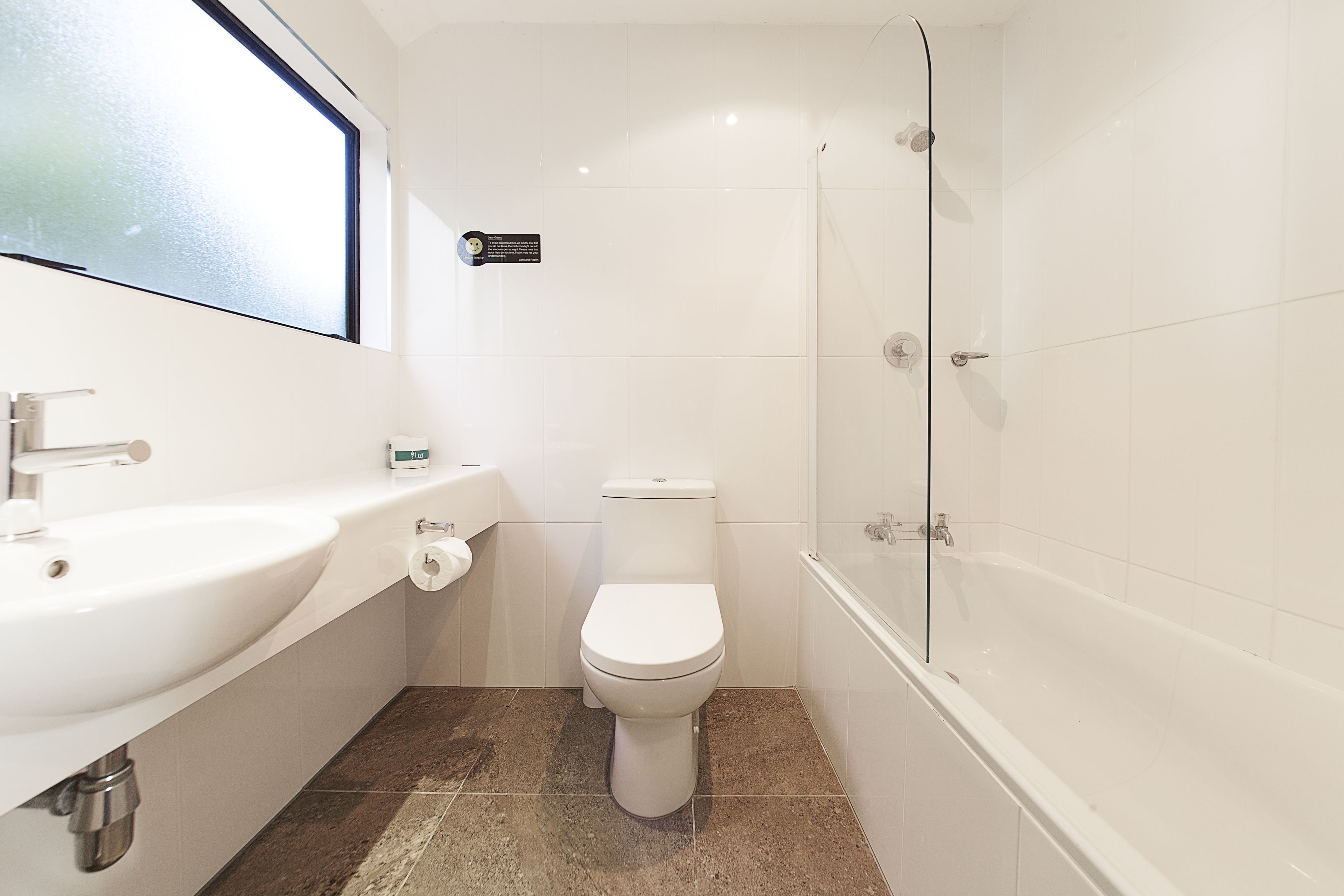 A bathroom with a white sink, toilet, and bathtub.