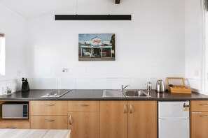 A kitchen with a microwave, sink, and a refrigerator.