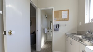 Et moderne køkken med rustfrie apparater, trægulv og udsigt til det tilstødende opholdsstue.