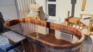 A wooden hot tub with a built-in seat and a small table. - Anchorage Motel Apartments (Te Anau)