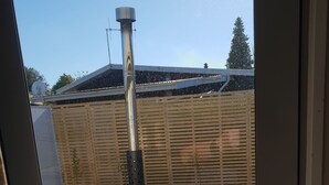 A wooden hot tub with a metal pole in a backyard. - Anchorage Motel Apartments (Te Anau)