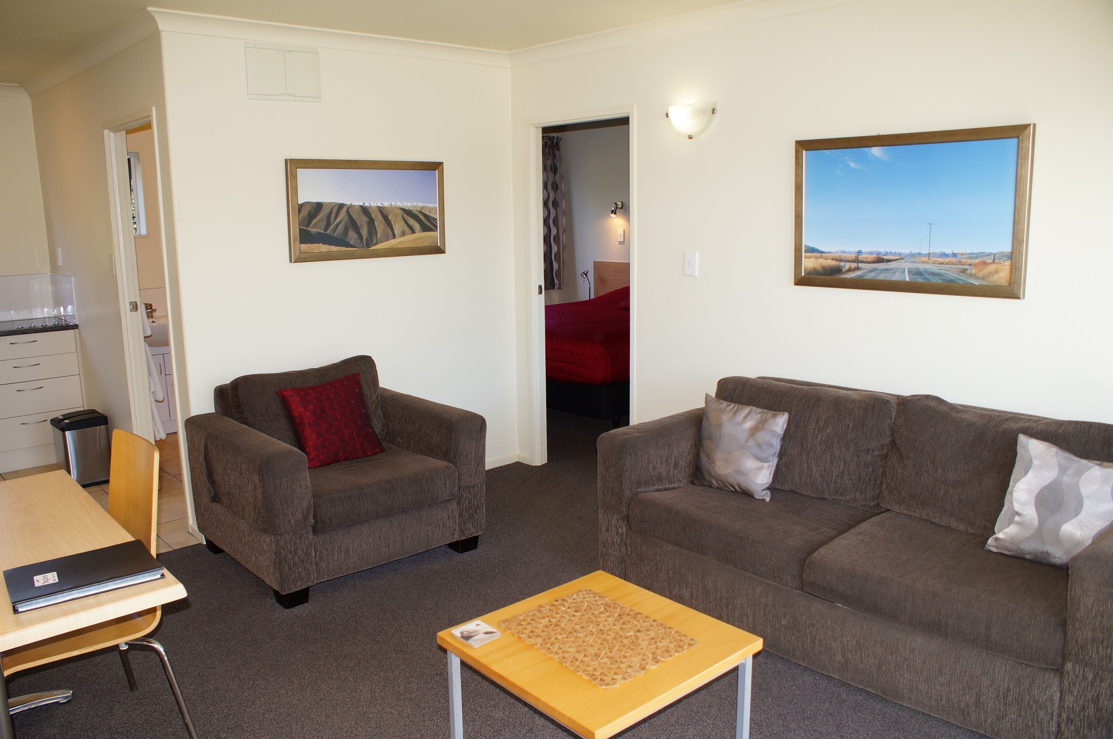 A living room with two sofas, a coffee table, and a painting on the wall.
