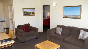 A living room with two sofas, a coffee table, and a painting on the wall.