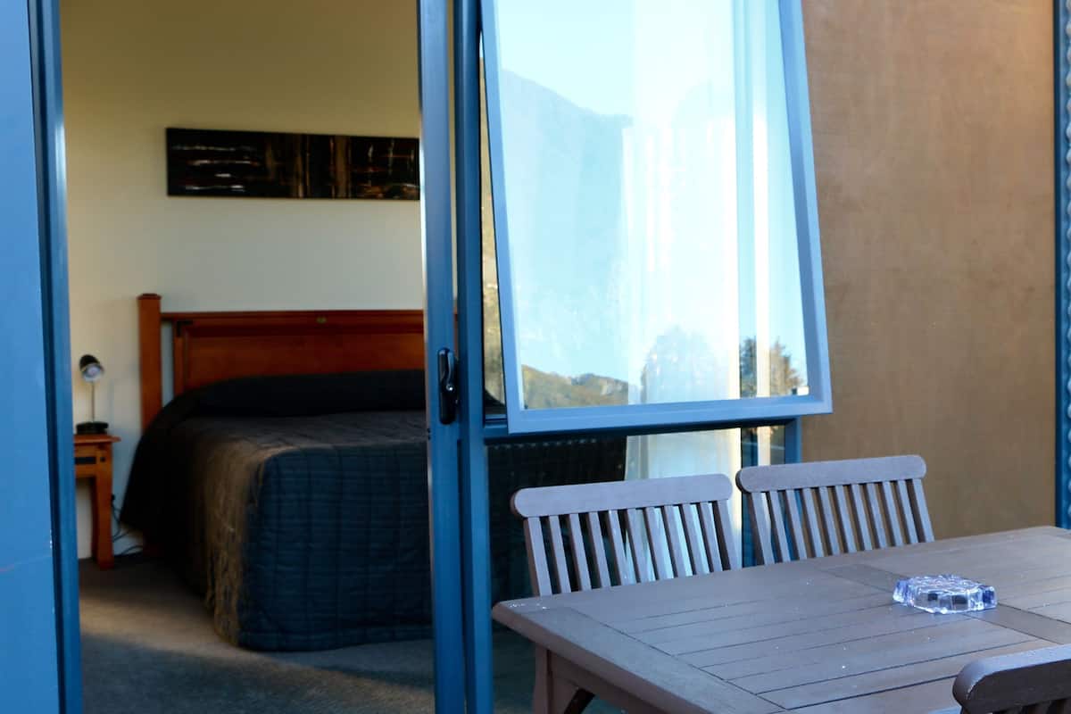 A room with a bed, a table, and a window.