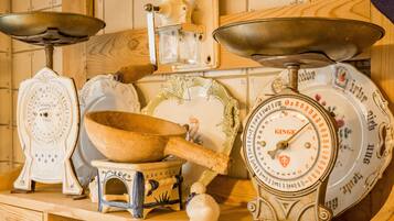 A collection of vintage kitchen scales and measuring devices on a wooden shelf.