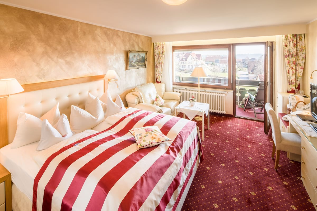 Une chambre d’hôtel avec un grand lit, un bureau et une vue sur la ville.