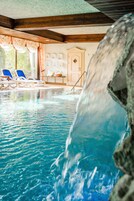 Una piscina cubierta, sombrillas, tumbonas