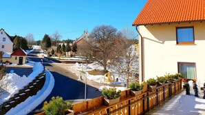 A residential street with snow-covered sidewalks and a clear blue sky.