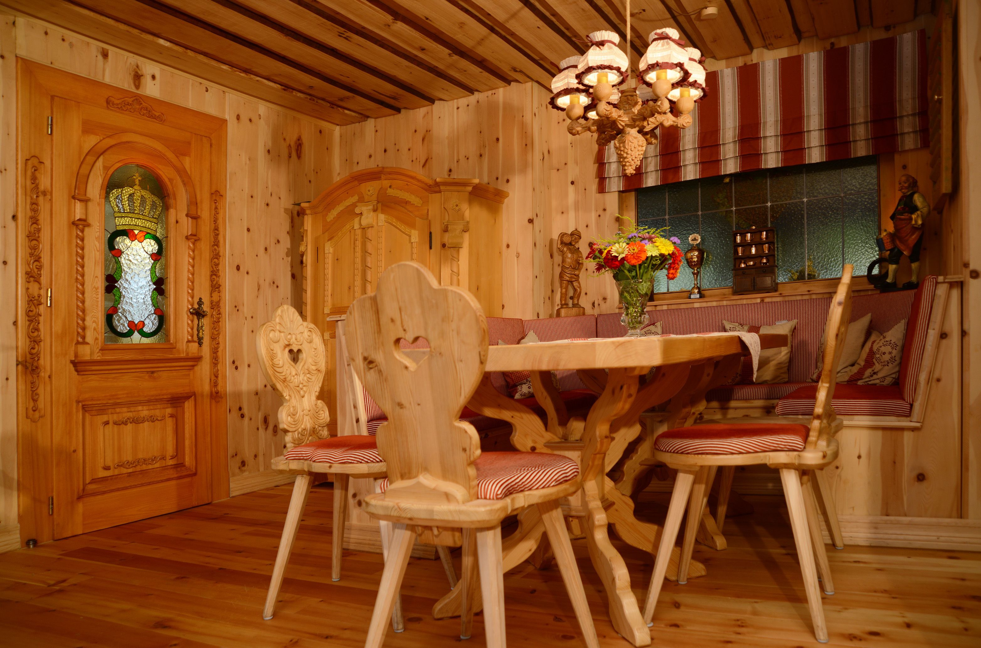 Ein Holzinterieur mit einem Esstisch, Stühlen und einer Chandelieber.