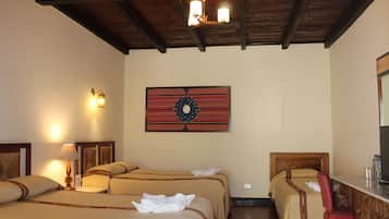 Habitación de hotel con dos camas, techo de madera, lámpara fijada a la pared y una obra de arte enmarco.