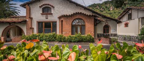 A traditional house with a brick facade, arched windows, and a stone foundation.