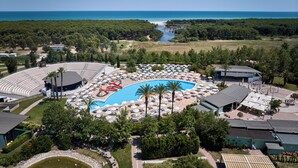 An aerial view of a resort with a swimming pool, sun loungers, a theater, and a view of the sea. - Torreserena Resort (Ginosa)