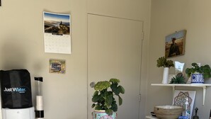 A reception area with a water dispenser, a potted plant, and a calendar on the wall.