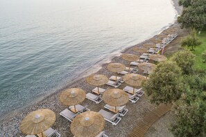 En la playa, sillas reclinables de playa, sombrillas, toallas de playa