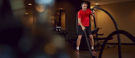 A gym with exercise equipment, including a stationary bike and a rope machine.