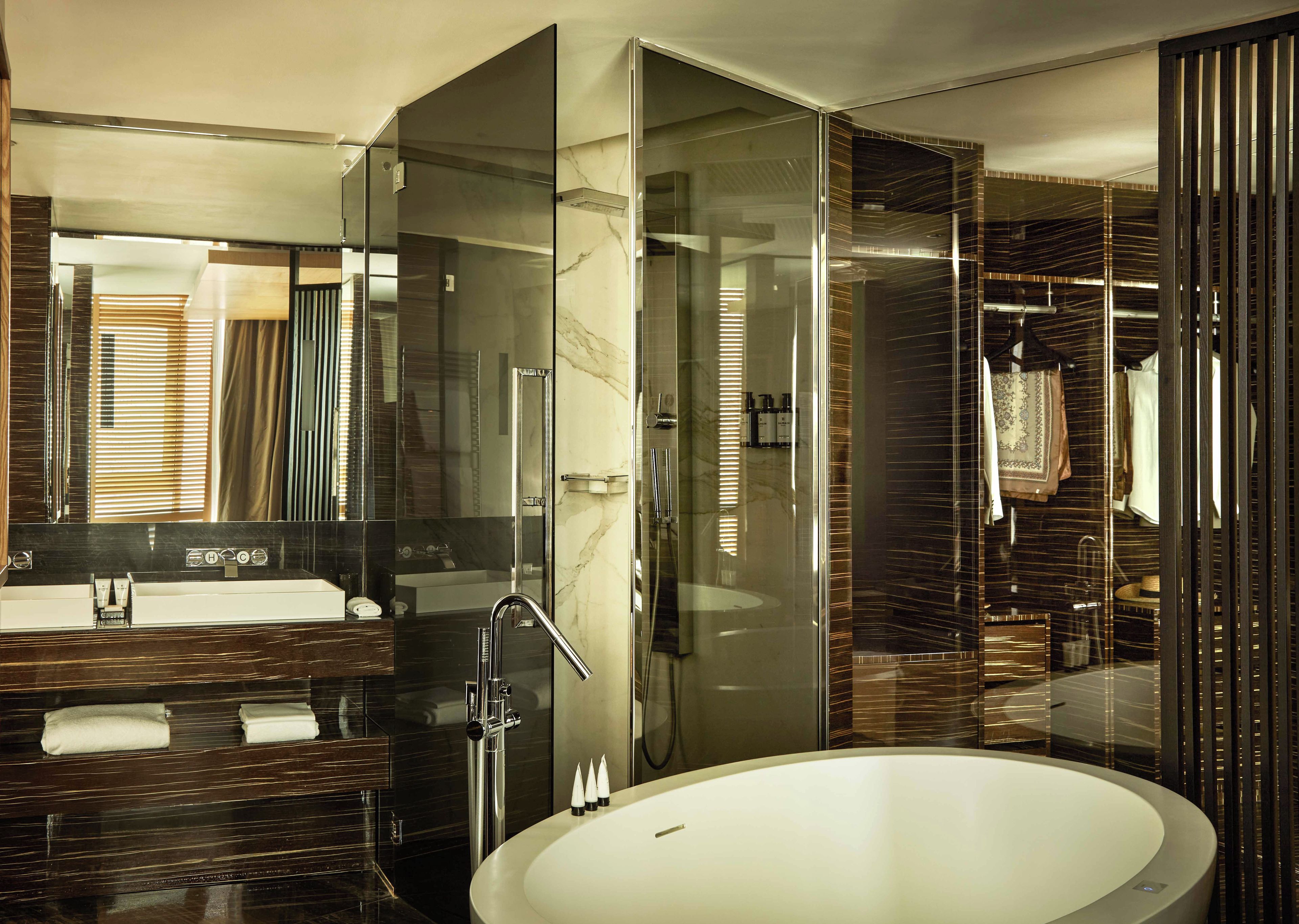 A modern bathroom with a large bathtub, a glass-enclosed shower, and a vanity with a mirror.