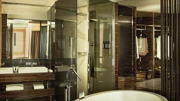 Un baño moderno con una bañera grande, una ducha con cerramiento de vidrio y un tocador con espejo.