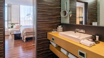 A modern bathroom with a large mirror, a double sink, and a walk-in shower.