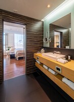 Une salle de bain moderne dotée d’un grand miroir, d’un double vasque et d’une douche à l’italienne.