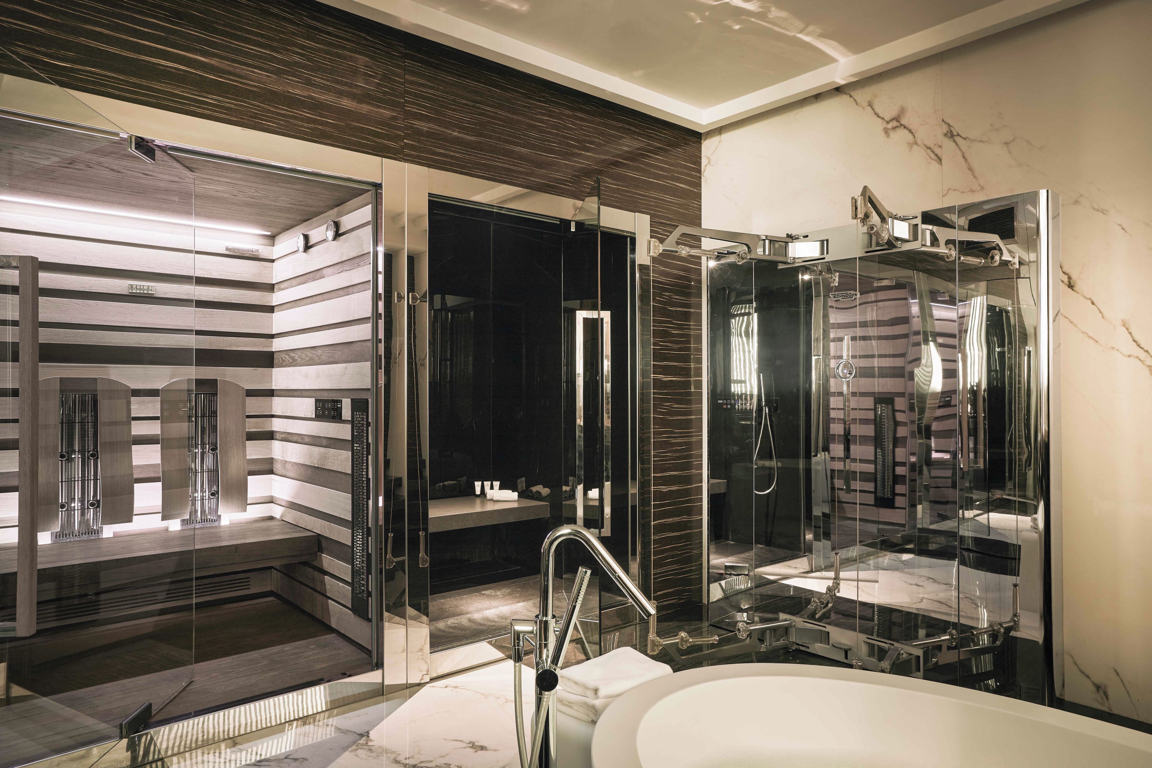 Une salle de bain moderne dotée d’une douche à parois de verre, d’une baignoire sur pieds et d’un meuble-lavabo avec un miroir.