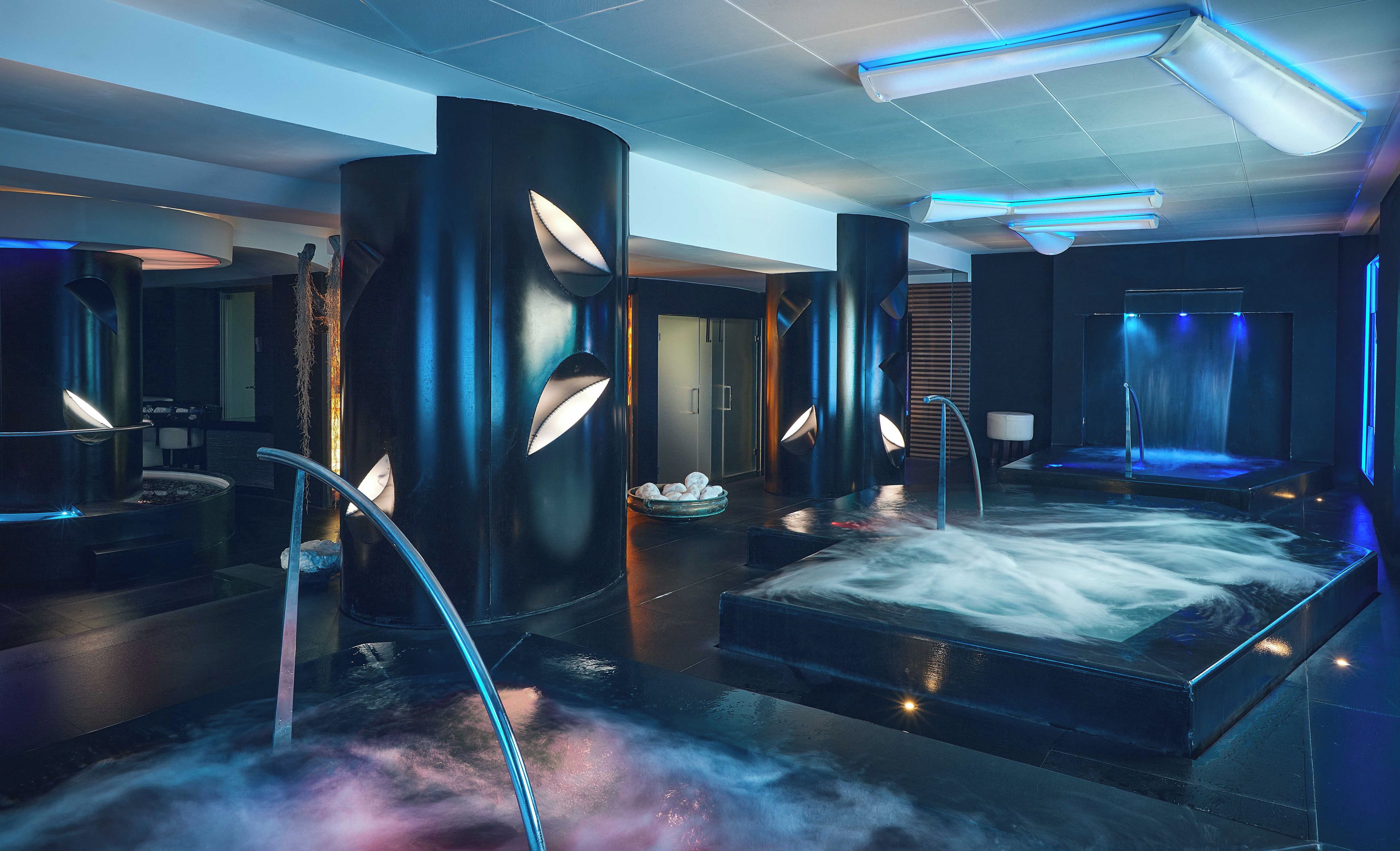 Een moderne spa met vloerverwarming, een sauna en een massagetafel.