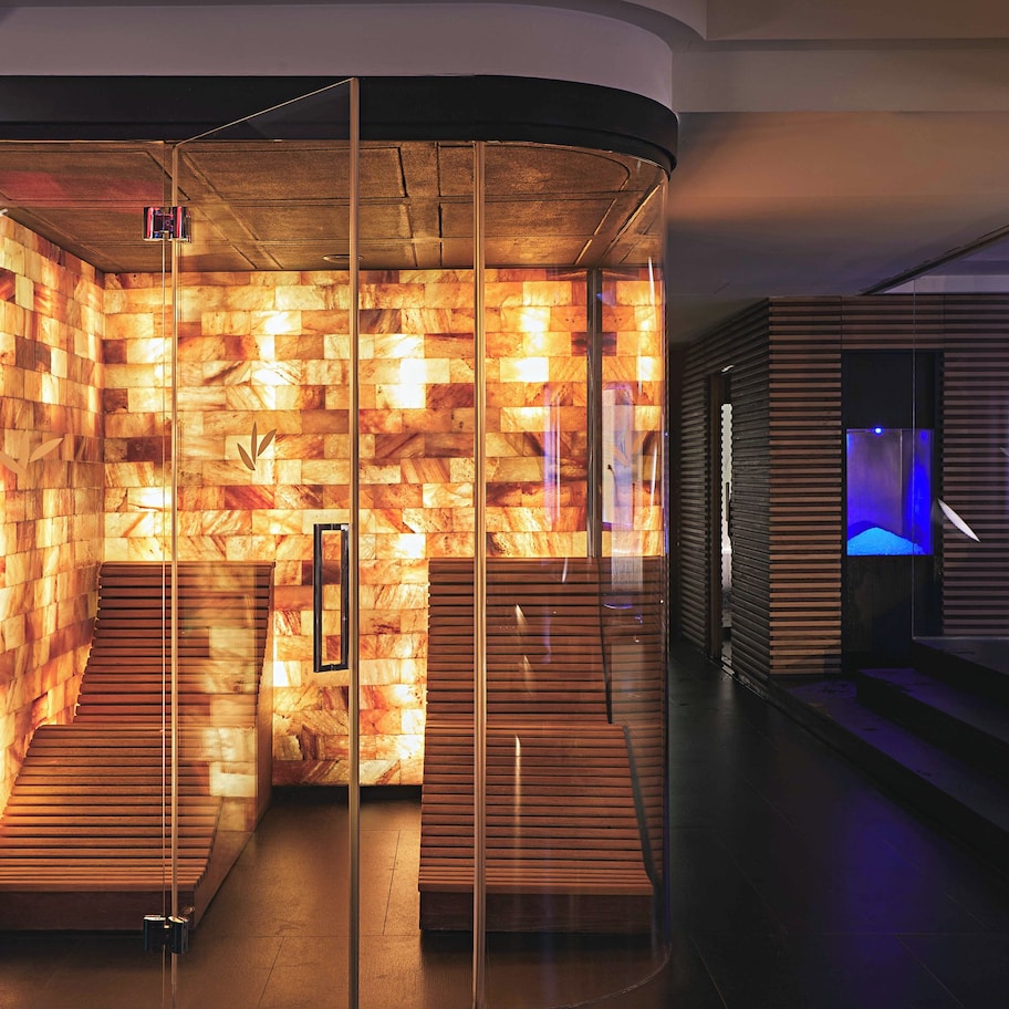 A modern interior with a wooden wall design, a staircase, and a blue-lit area.