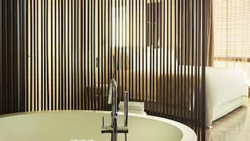 A modern bathroom with a freestanding bathtub, a shower, and a toilet.