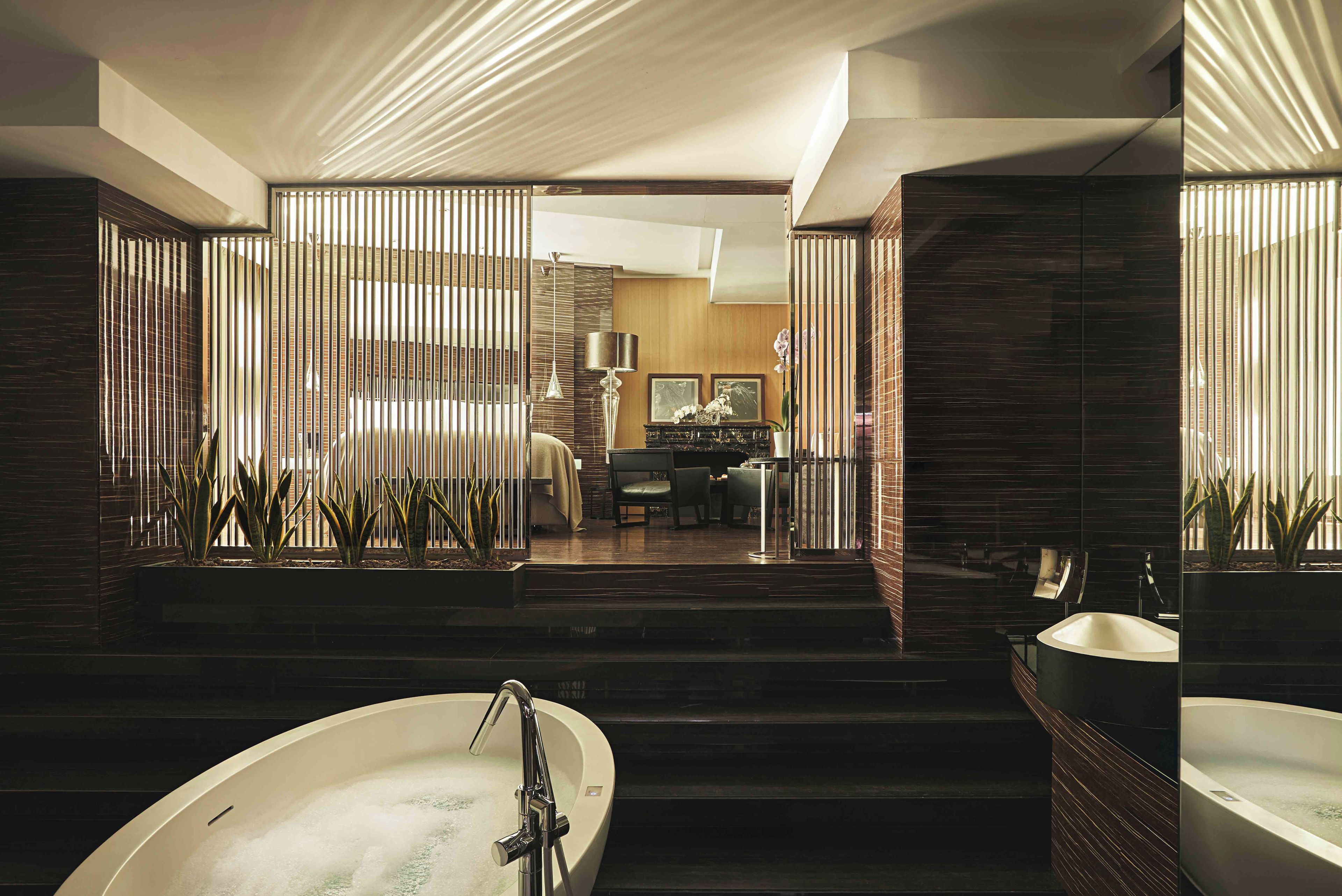 A modern bathroom with a freestanding bathtub, a separate sink, and a shower area.
