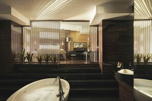 A modern bathroom with a freestanding bathtub, a separate sink, and a shower area.