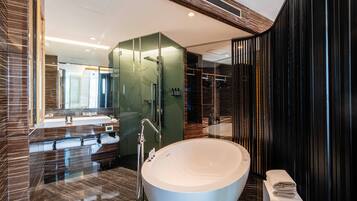 A modern bathroom with a large freestanding bathtub, a glass-enclosed shower, and a vanity with a mirror.