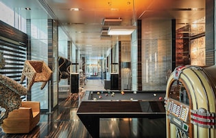 Een modern interieur met een pooltafel, houten meubels en een jukebox uit een vervlogen tijd.