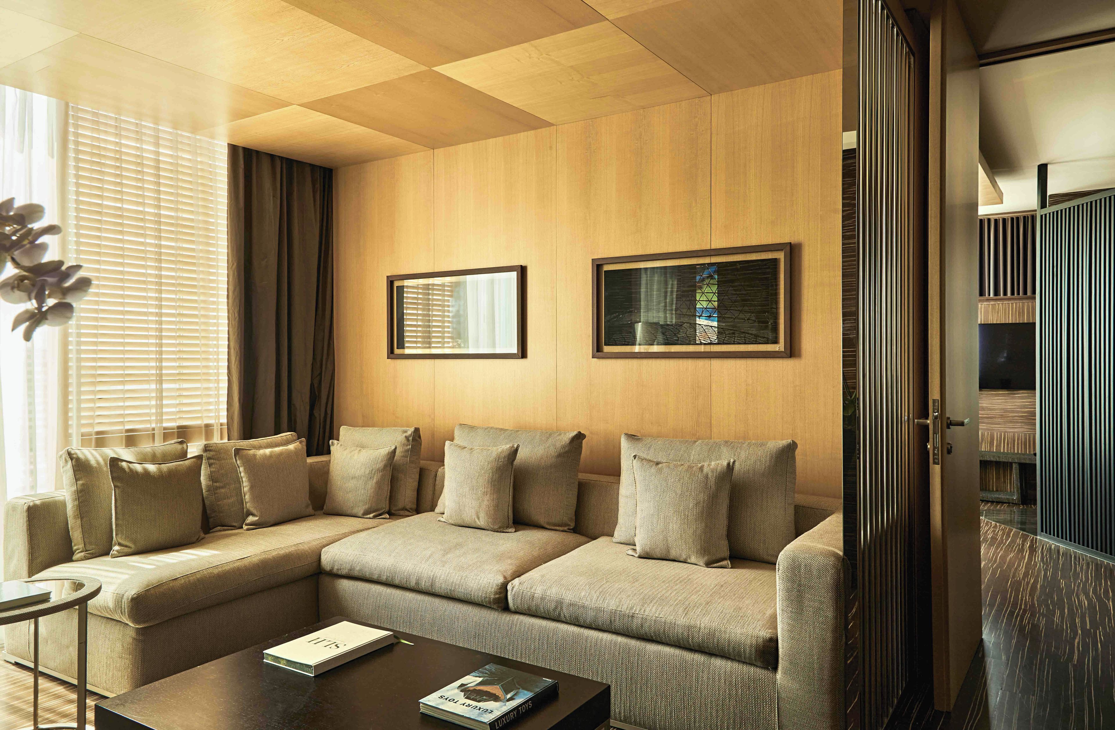 A modern living room with a sectional sofa, a coffee table, and two framed pictures on the wall.