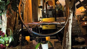 A room with a hanging birdcage, a chandelier, and a staircase with patterned tiles. - The Gallery Inn (San Juan)
