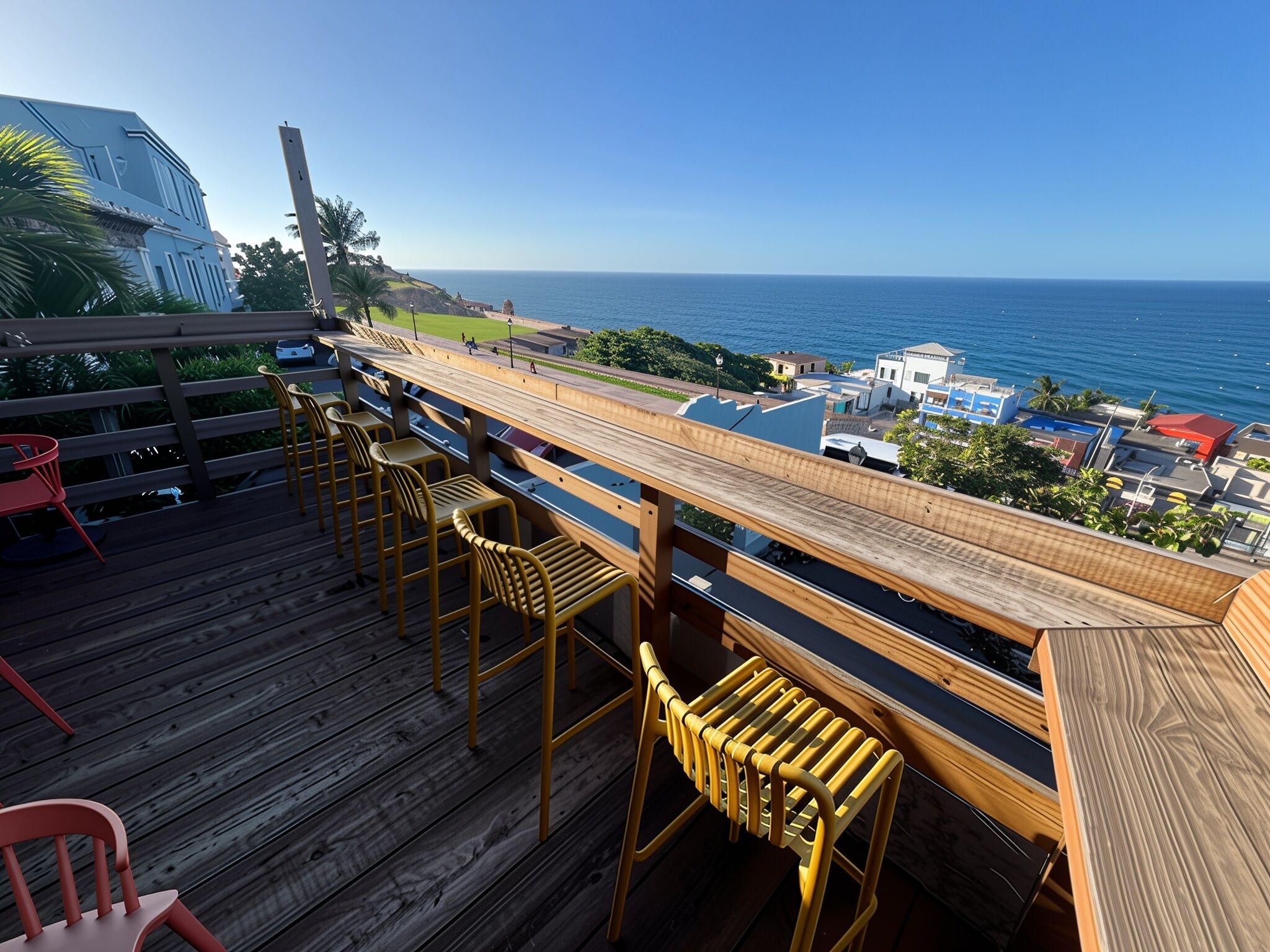 A wooden deck with bar stools overlooking a coastal view.