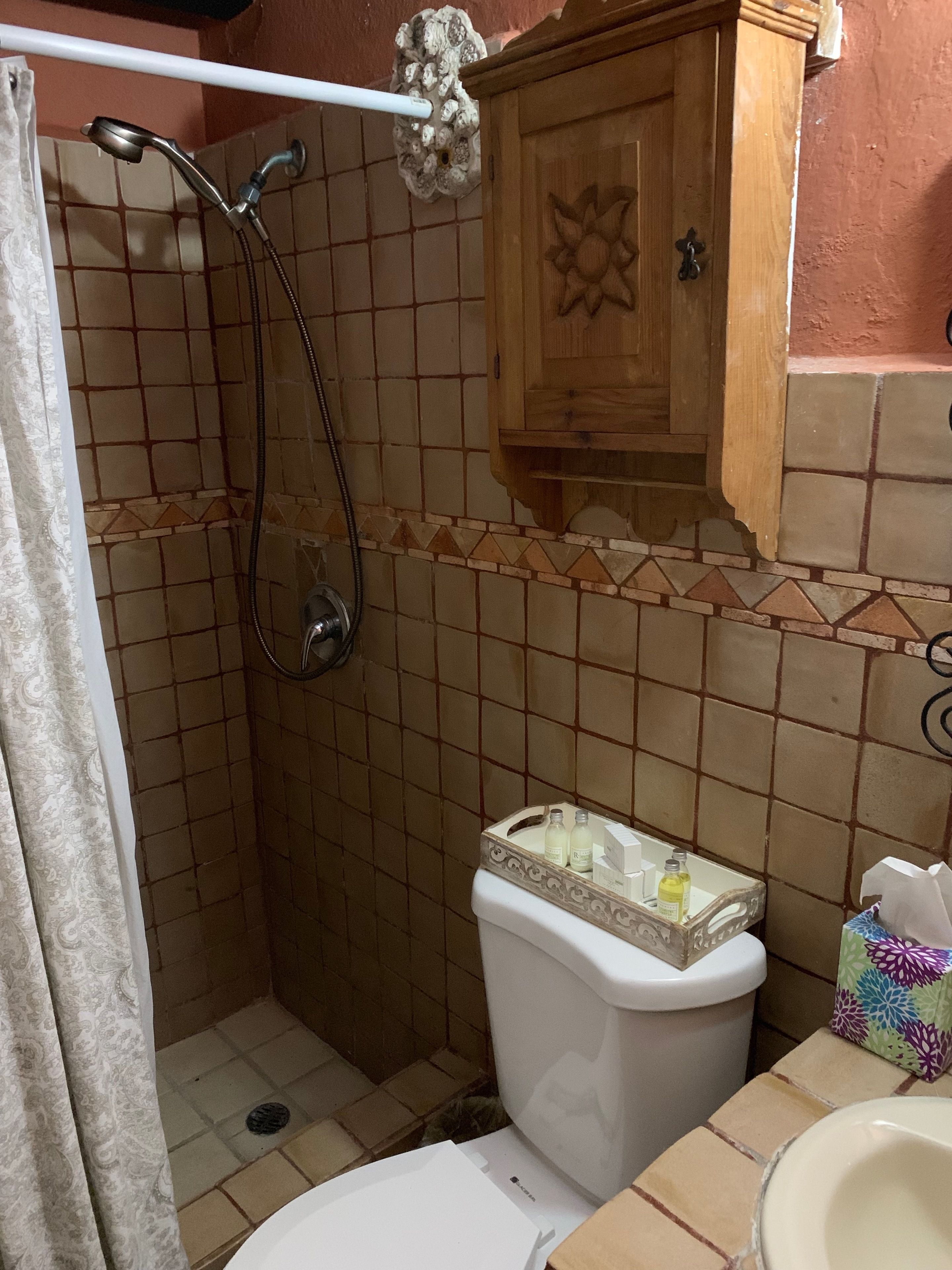 Ein Badezimmer mit Dusche, Toilette und Waschbecken.