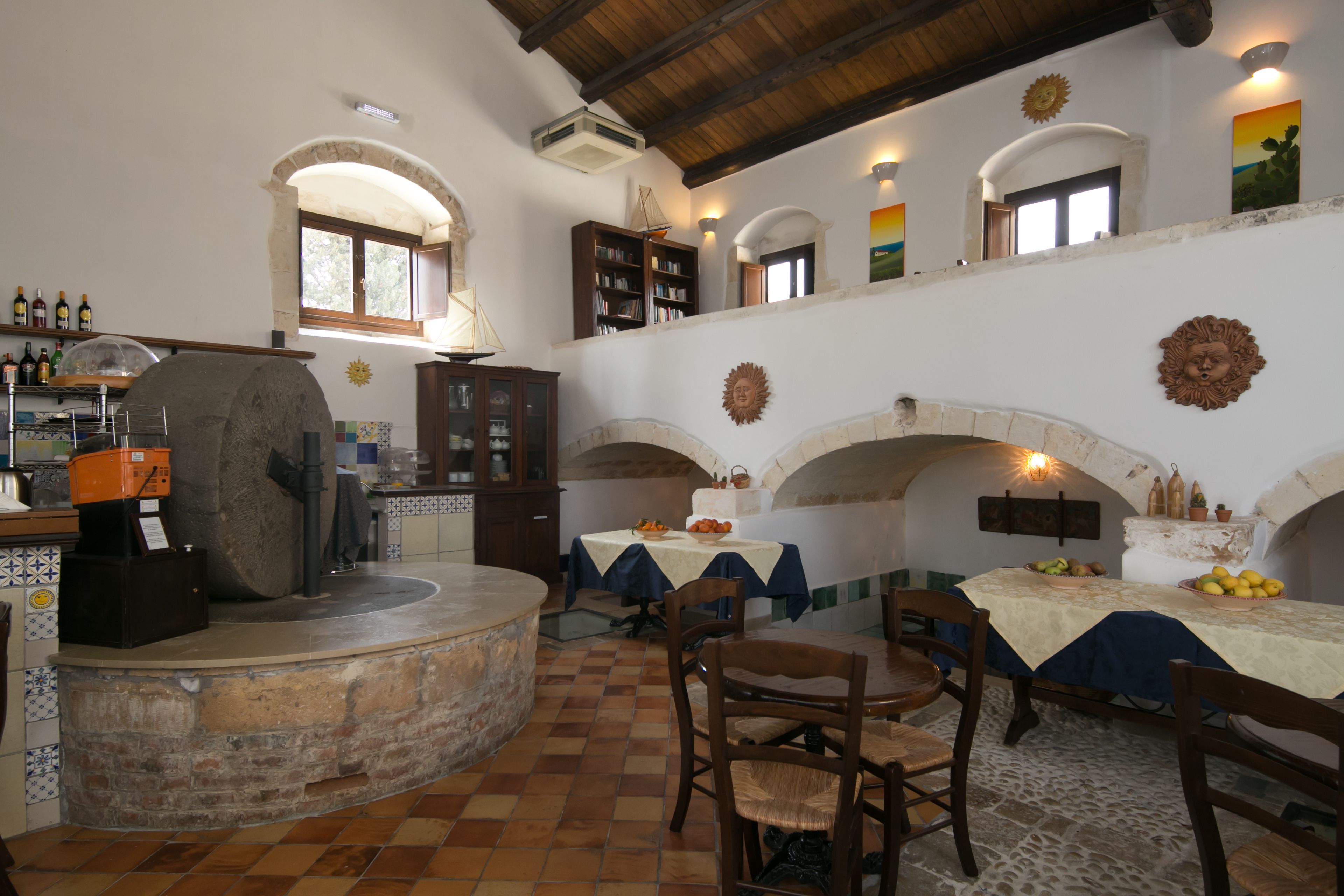 Un comedor rústico con paredes de piedra, muebles de madera y un horno de piedra.
