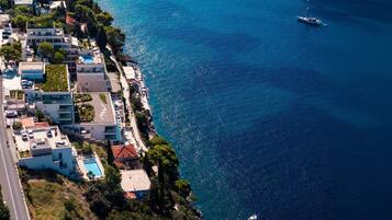 A coastal hotel with a swimming pool, a marina, and a road adjacent to the property.